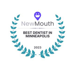 Logo of "newmouth" featuring a purple location pin icon above the text "best dentist in minneapolis 2023," encircled by a laurel wreath.